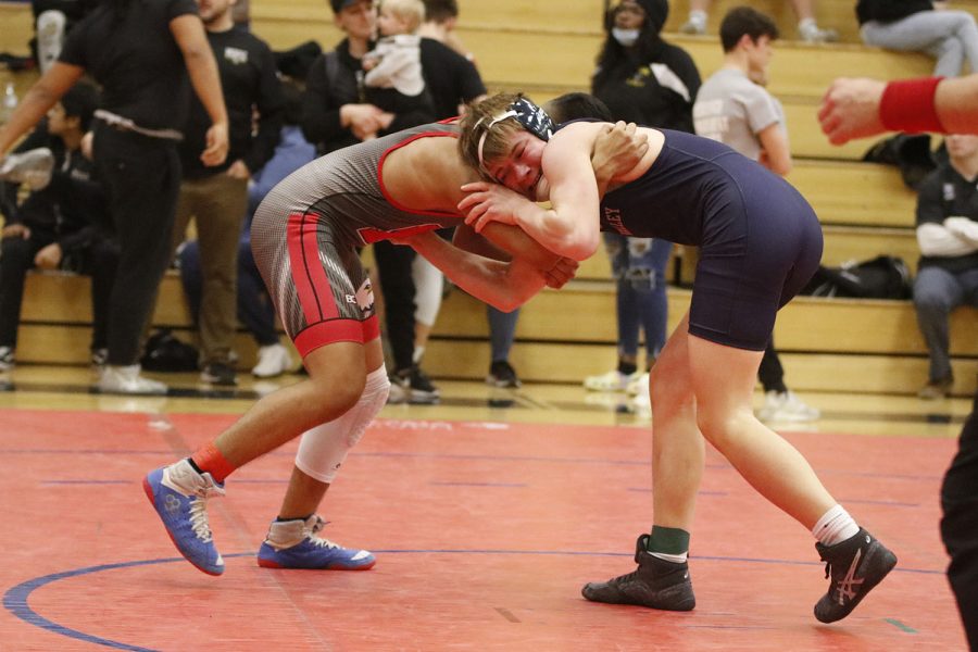 Struggling in the match, sophomore Hayden Applebee grabs his opponents arms and tries to pull him down.