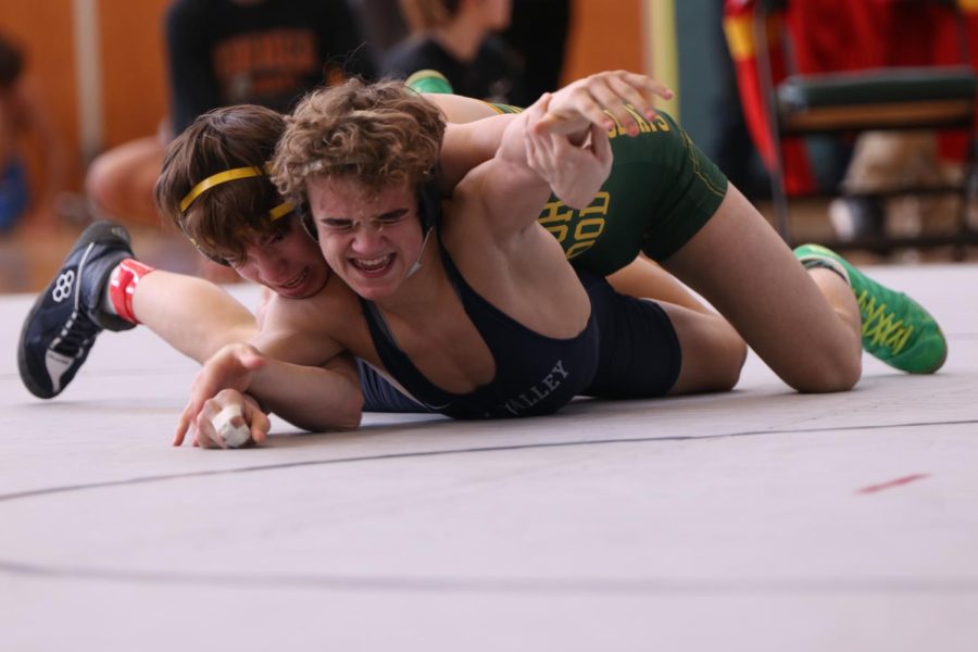 Struggling for position, sophomore Brady Mason fights to defend against his opponent. 