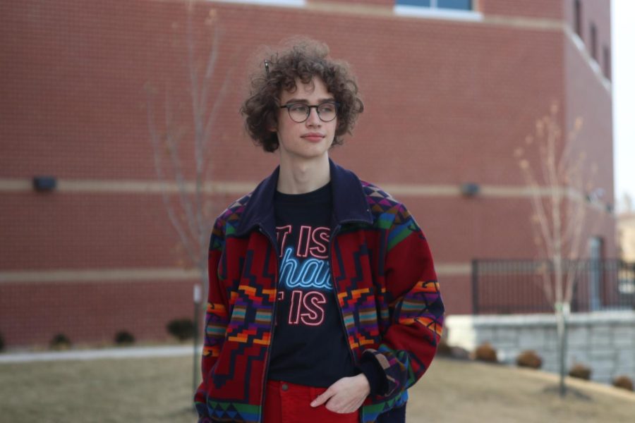 Hand in pocket, junior Sean Olin wears one of his favorite thrifted jackets. Most of Olins clothes come from thrift stores or his grandparents closets.