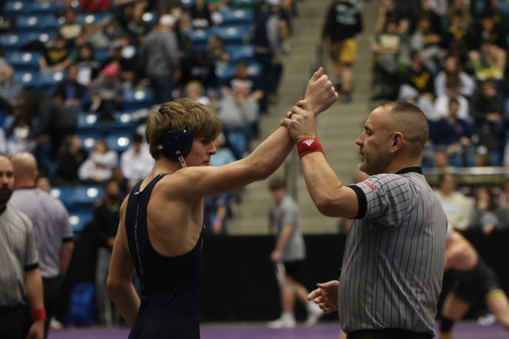 Having his hand held up by the ref, sophomore Colin McAlister wins his match allowing him to qualify for state semi finals.