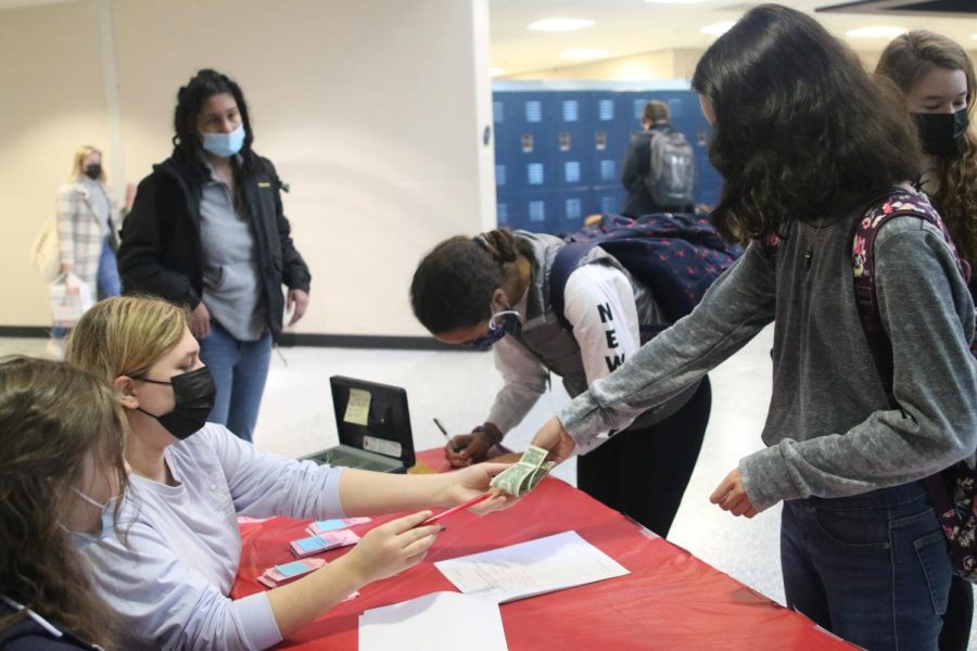 Collecting the money for Crush sales, senior Anna Springer helps a student buy one.