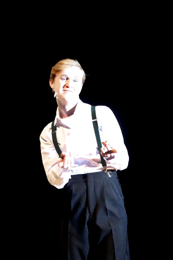 Junior Carter Harvey, introduced as Mr. Theater, points at the crowd while he passes the stage.