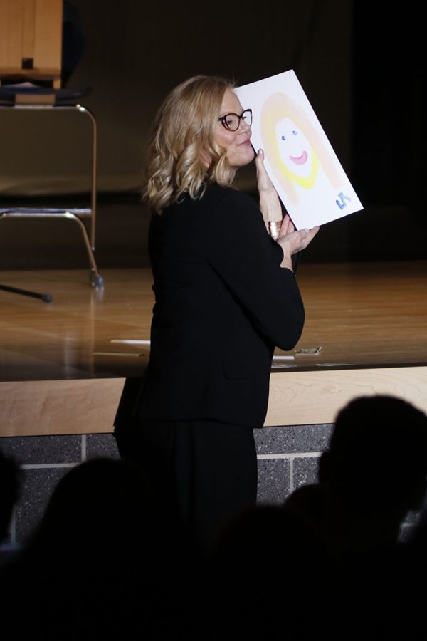 Pageant judge principal Dr. Gail Holder holds up a finished portrait of her painted by junior Lucas Robins