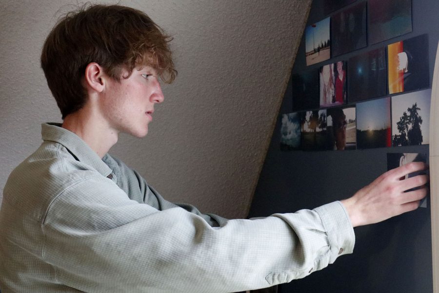 In front of his film wall, junior Sonny Pentola places another film picture up.