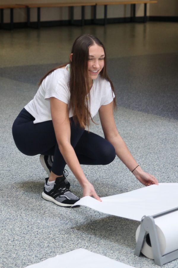 Paper in hand, junior Madison McClure gets paper to make a banner Monday, Feb. 21.  