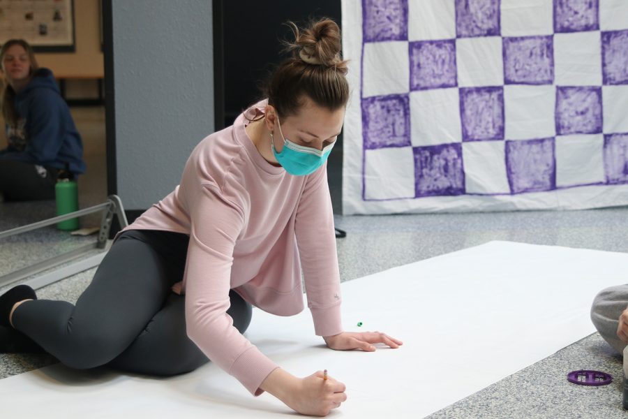 Pencil in hand, senior Alyssa Canning works on a banner for the foyer Monday, Feb. 21.

