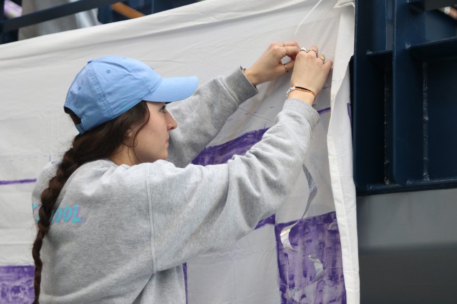 Concentrating, senior Quincy Hubert focuses on hanging the photo booth banner Monday, Feb. 21.
