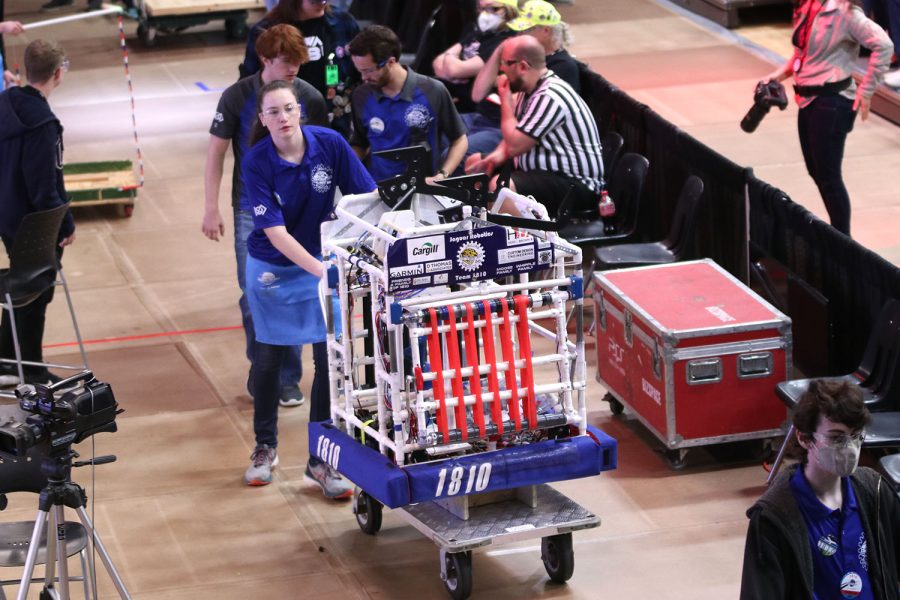 With the robot lifted onto a cart, senior Maddie Vosburg pushes the robot to the pit where they wait for their next round and make adjustments. 