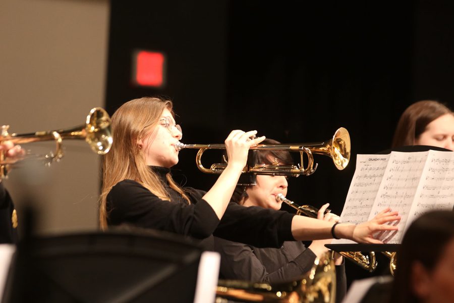 Freshman Joah Clark plays the trumpet while holding down her music sheet.