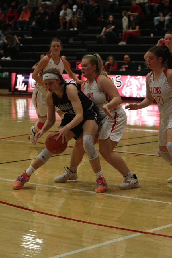 Protecting the ball, senior Emree Zars puts herself in between the players and the ball.
