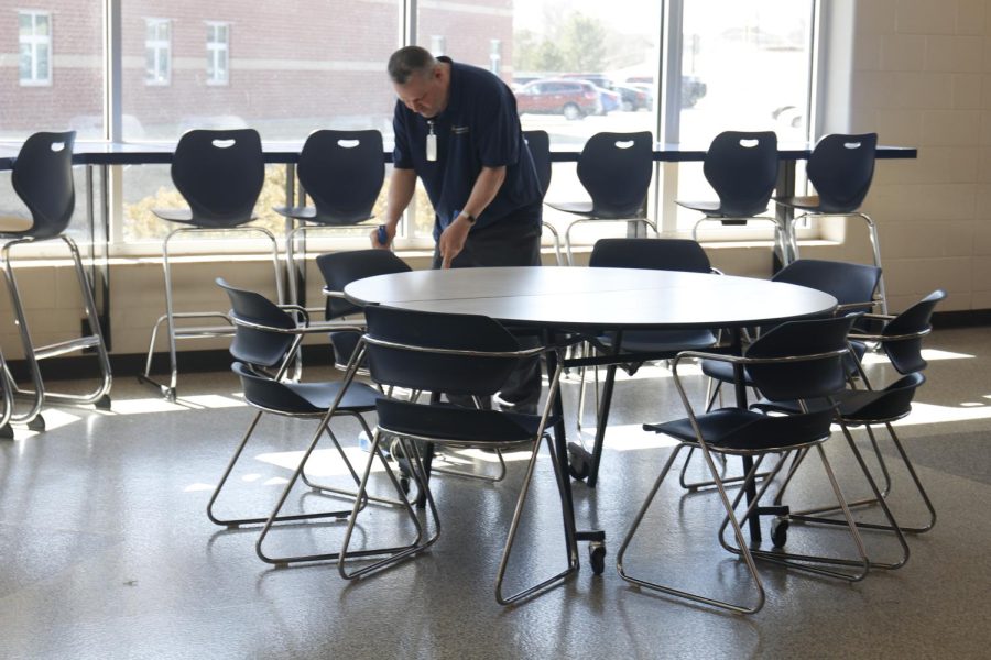 Cleaning the senior cafe, custodian Gerald Young picks up food from lunch, Wednesday Mar. 2. One of Youngs jobs is to clean up rooms and set up for home sports games.