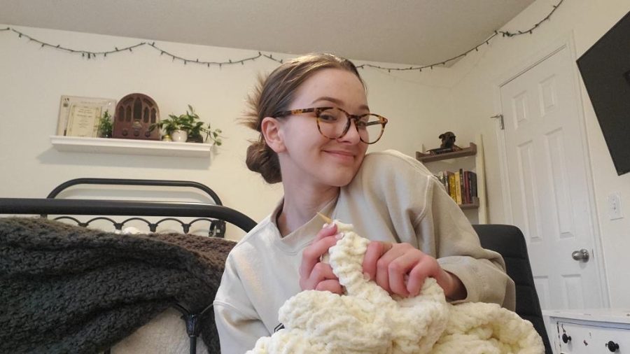 Sitting in the comfort of her home, sophomore Grace Cormany works on knitting a blanket on Monday, Feb 28.