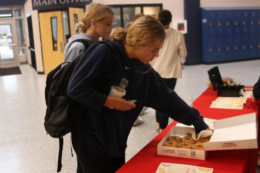 Picking out a donut, freshman Caroline Hooper supports SNHS. 