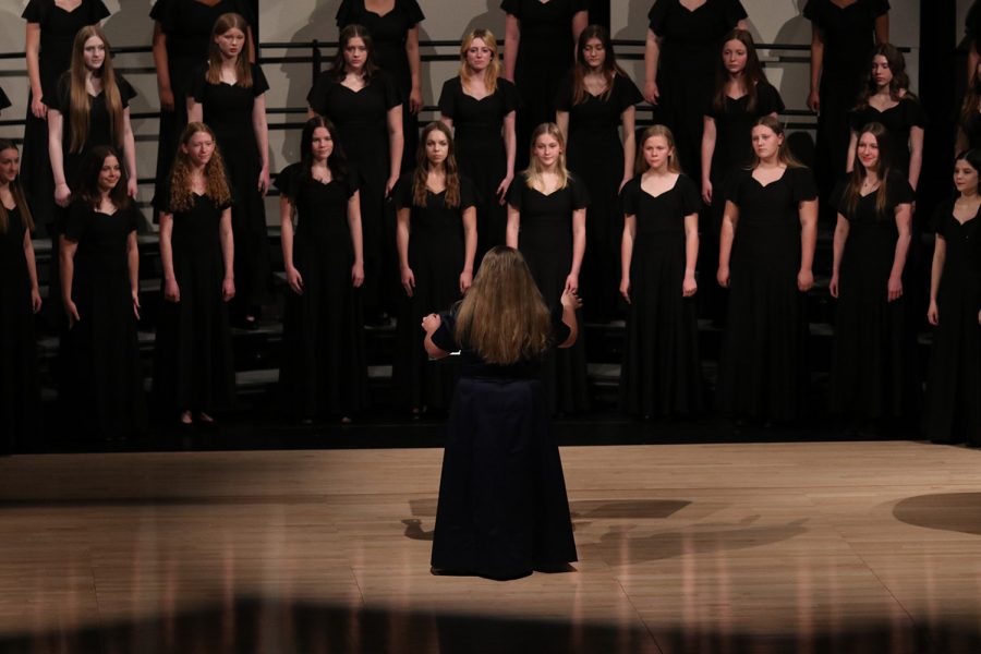 In front of the Grace Notes choir, senior Hayley O’Keefe directs the choir during the song “In Te Speravi.” 
