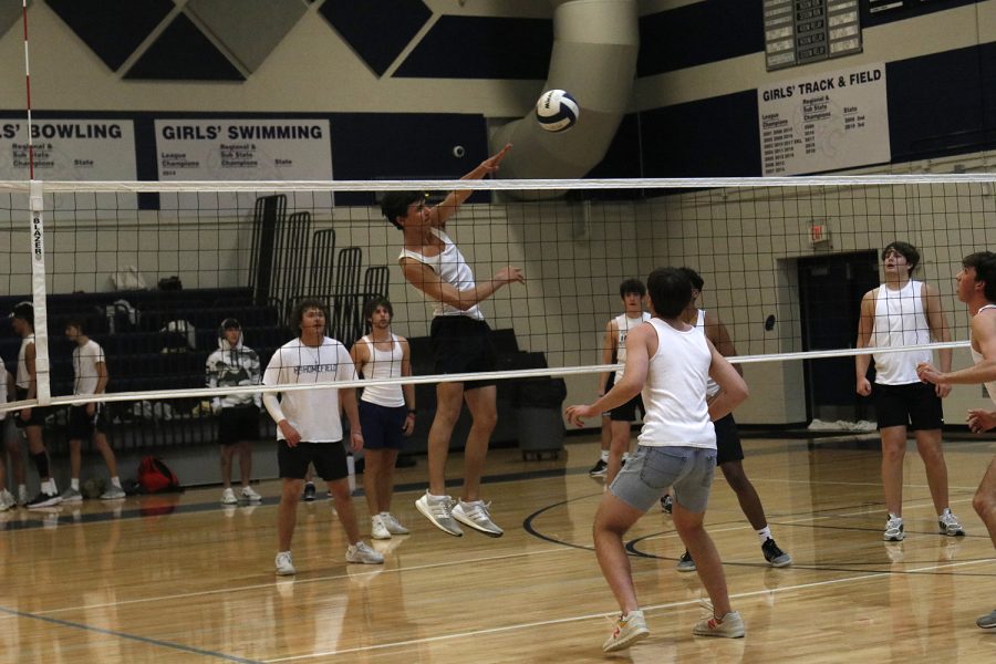 Jumping in the air, senior Brock Olson spikes the ball.