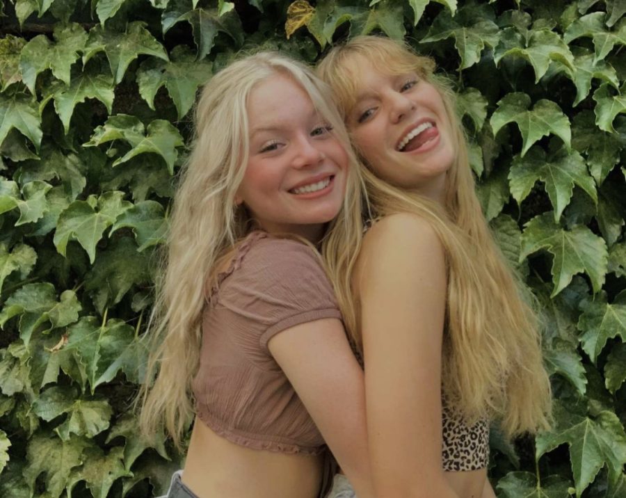 With their arms around each other, sophomores Keira Franken and Megan Kephart pose for a photo in front of foliage. Franken and Kepharts friendship predates their kindergarten years.