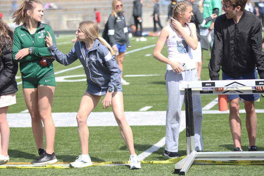 Yelling down the track at her teammate, senior Bridget Roy cheers on senior Katie Schwartzkopf. 