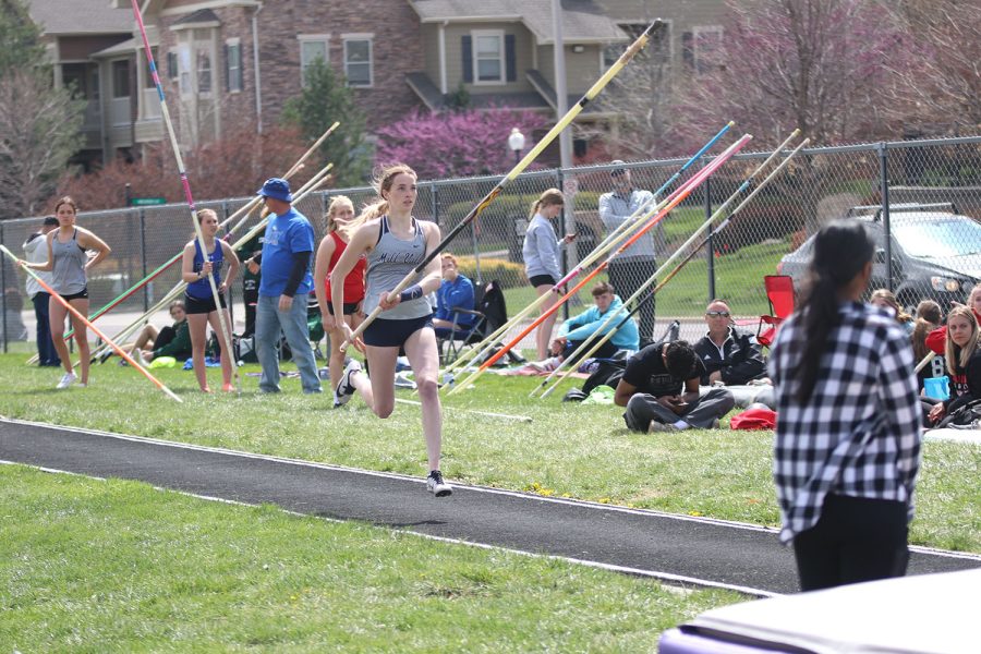 Holding the pole at her side, junior Libby Strathman runs toward the pit getting ready to vault. 