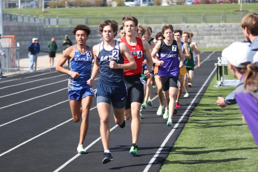 Pacing himself, senior Chase Schieber holds his lead while his teammates cheer him on from the field. 