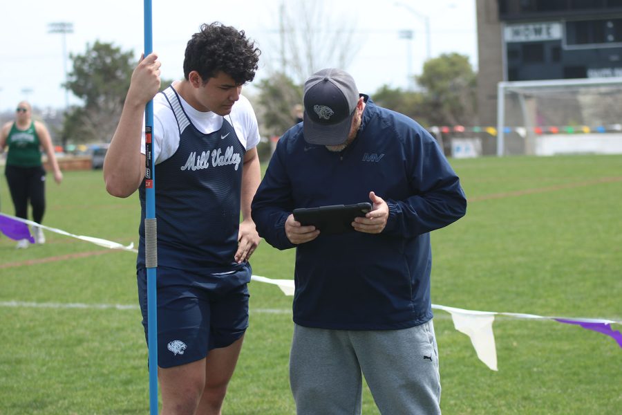 Watching the footage of his last throw, sophomore Truman Griffith talks with coach Cory Wurtz on how to improve. 