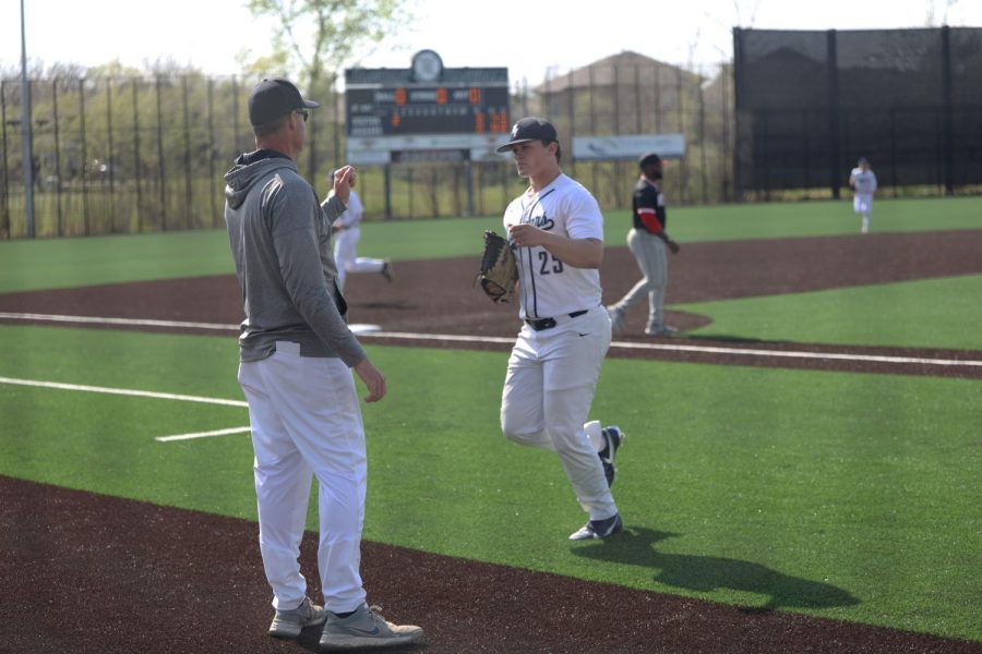 Returning from the mound after the first inning, Senior Grant Rutkowski fist bumps Coach Strickland after giving up the only two runs of the game. 