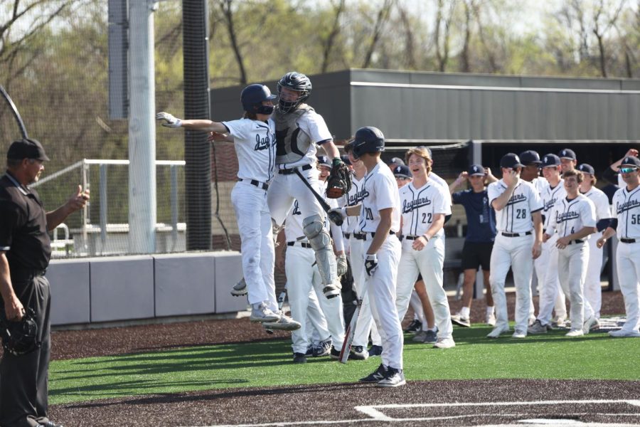 Senior Cody Moore congratulates sophomore Adam Seymour after hitting a home run over the right-field wall.