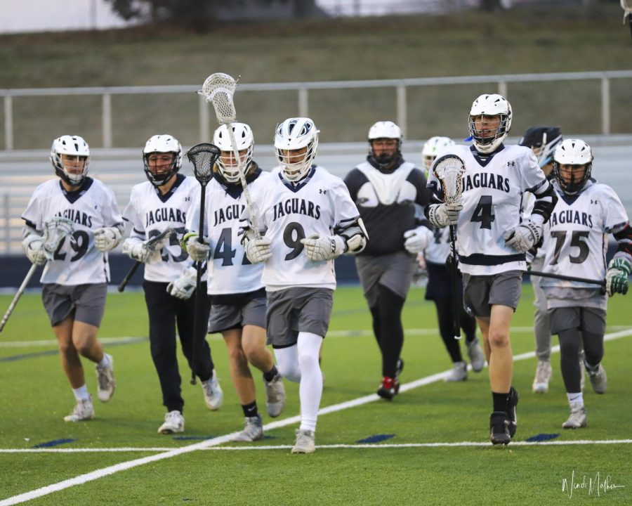 About to take on Blue Valley East on March 22, senior Jack Brackin leads the team onto the field. 