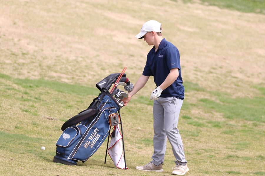 Near the golf bag, junior Matt Morgan selects which golf club to use for his next shot, getting a score of 89 at Falcon Lakes Golf Club Invitational Monday, April 11.