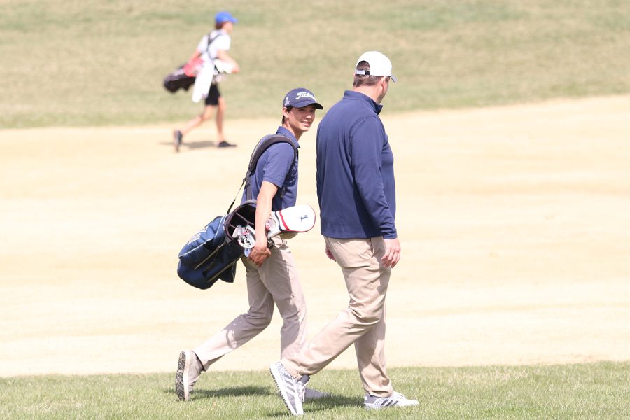 Walking+beside+each+other%2C+senior+Brock+Olson+and+head+coach+Drew+Walters+talk+while+they+walk+to+the+golf+ball.+Olson+finished+with+a+final+score+of+87+at+Falcon+Lakes+Golf+Club+Invitational+Monday%2C+April+11.