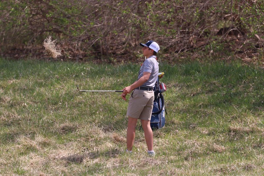 On the uncut grass, sophomore Jackson Sprecker attempts to hit his ball closer to the hole. At Falcon Lakes Golf Club Invitational Monday, April 11 Sprecker scored a 93.
