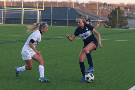 Facing a Gardner-Edgerton player, sophomore Julia Coacher attempts to move the ball away from her opponent.