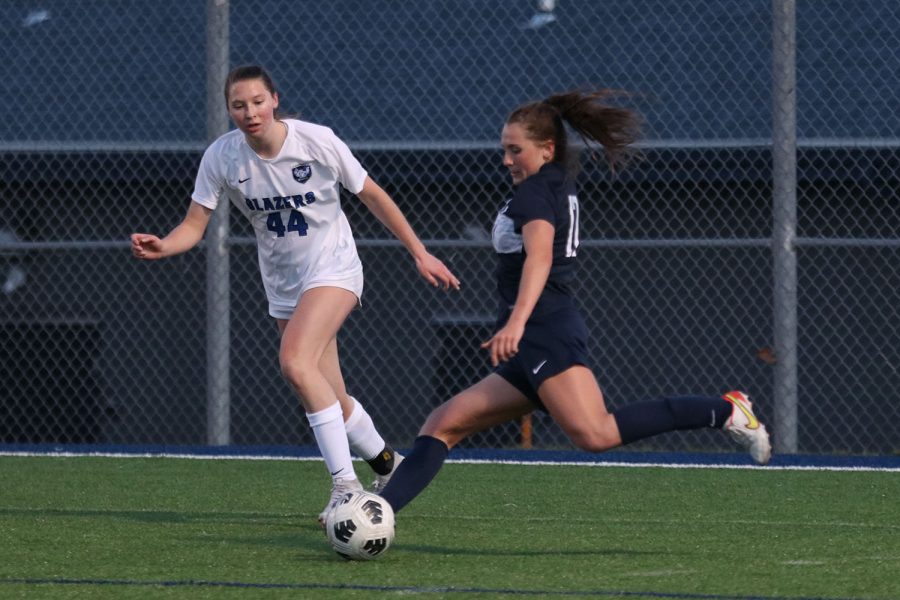 While stepping out in front of a player, junior Laney Reishus prepares to pass the ball toward the goal.