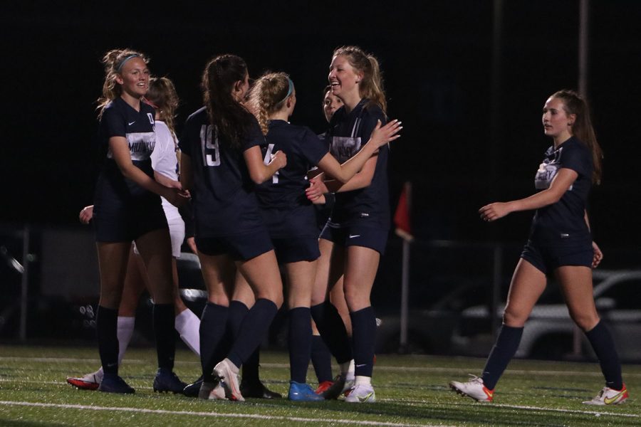 After scoring a goal, senior Kate Roth celebrates in a group with her team. Roth scored two goals to contribute to the final score of 3-0.