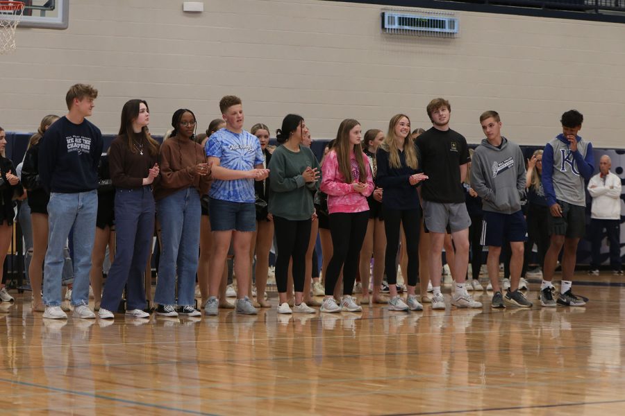 Standing side by side, DECA members clap for each other as they are recognized for placing at state.