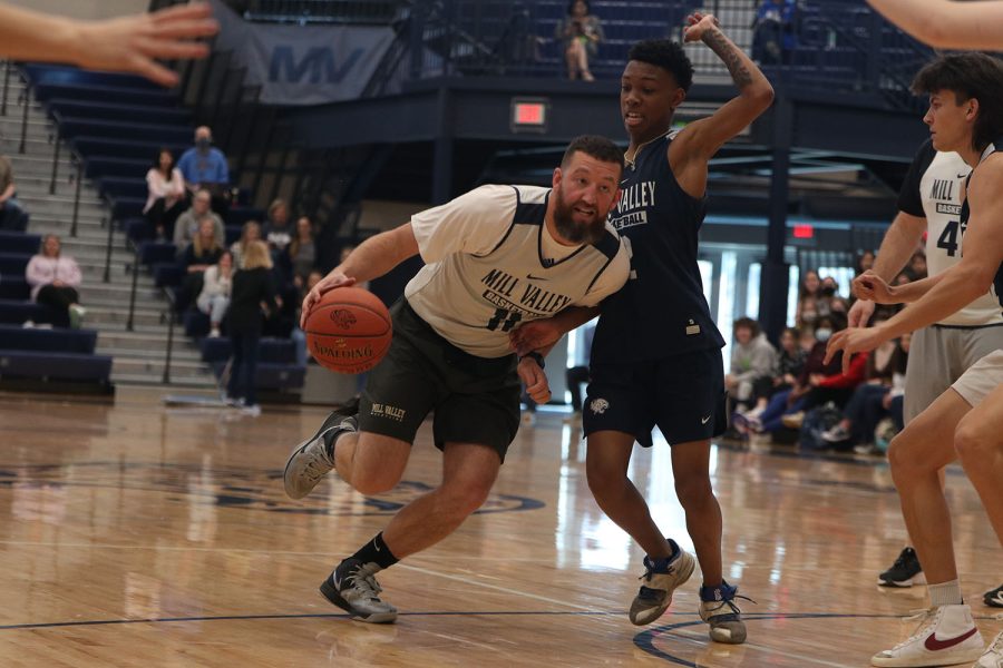 Working his way toward the net, athletic director Brent Bechard dribbles past the student team’s defense.