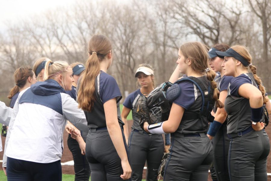Forming in a small circle, the team listens to Coach Jessica DeWilds pep talk  during the game Tuesday, Apr. 5
