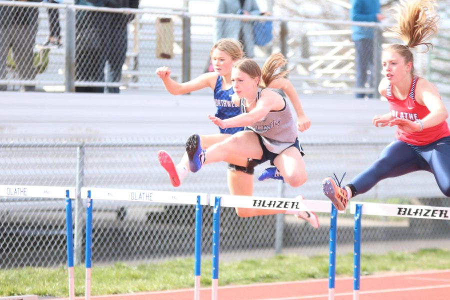 With her dominant leg in front of her, freshman Josie Benson looks on as she clears the first hurdle in the 100 meter hurdles race