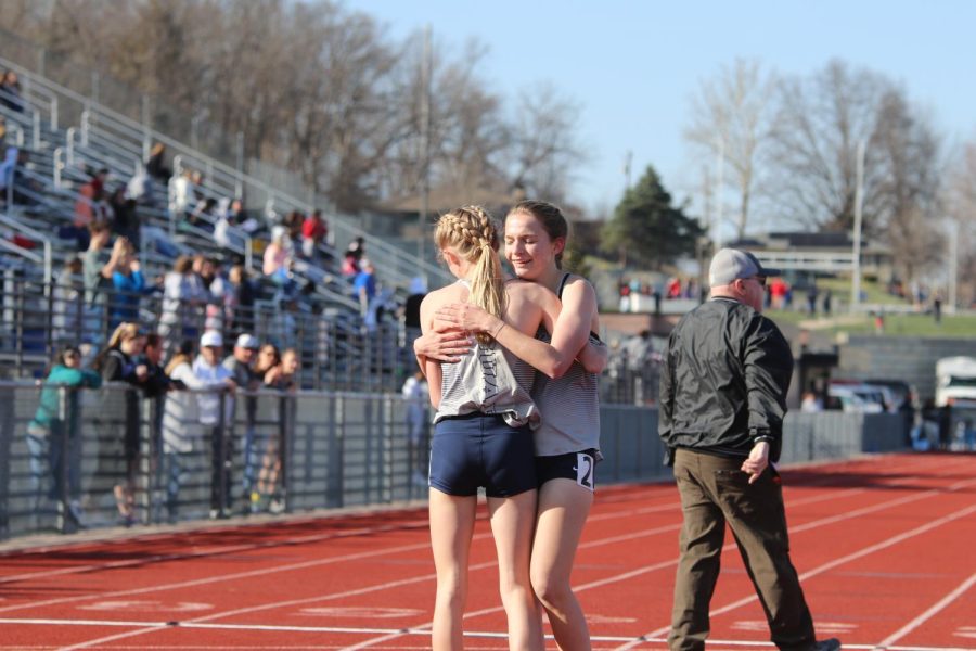 Celebrating their finishes in the 1600-meter race, freshmen Charlotte Caldwell and Meghan McAfee hug.
