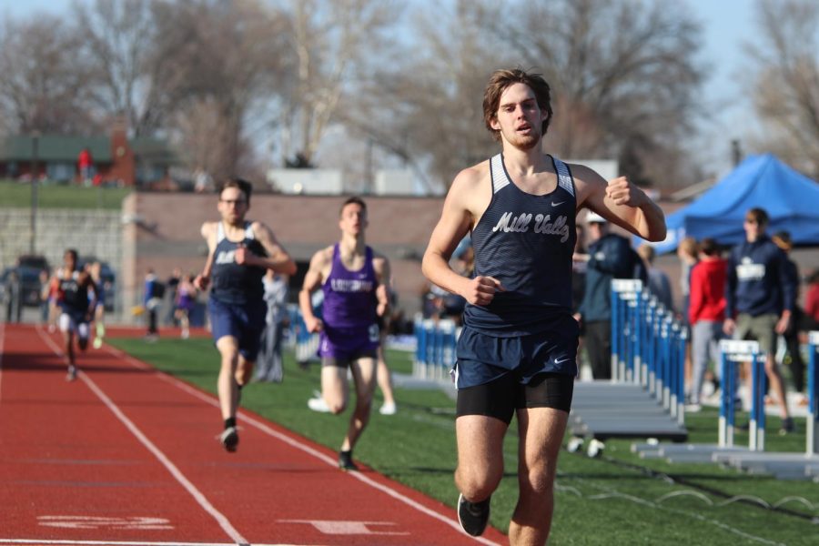 Pumping his fists, senior Chase Schieber celebrates his first place finish in the 1600-meter race.