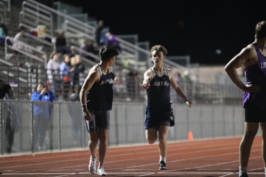 Initiating a hand-off, junior Finn Campbell holds out the baton to junior Dylan Nguyen.