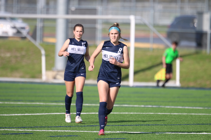 Sophomore Kate Ricker and junior Laney Reishus run to get the ball from their opponents on Thursday, April 21st.