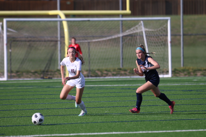 Sophomore Kate Ricker runs towards her opponent to steal the ball