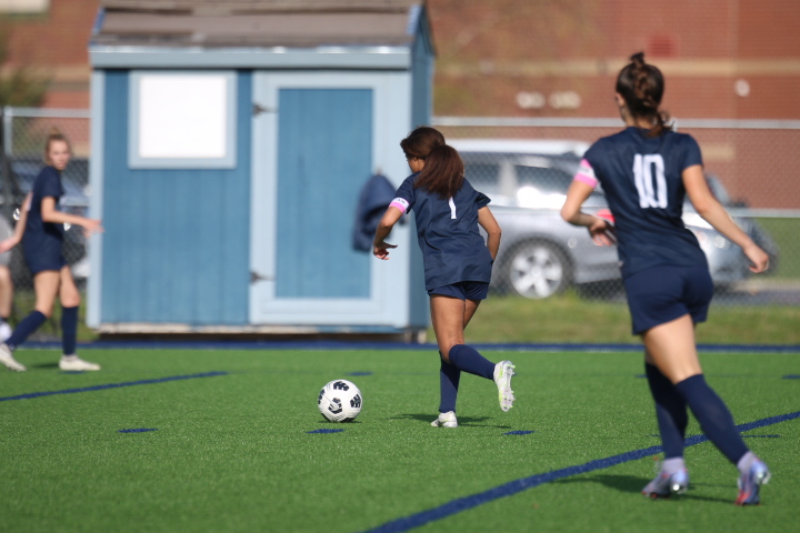 Team captain junior Acacia Weis runs toward the ball to pass to her teammates against Olathe East