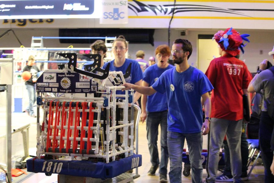 The robotics team carries their robot away from the field after a qualification match Friday, April 1