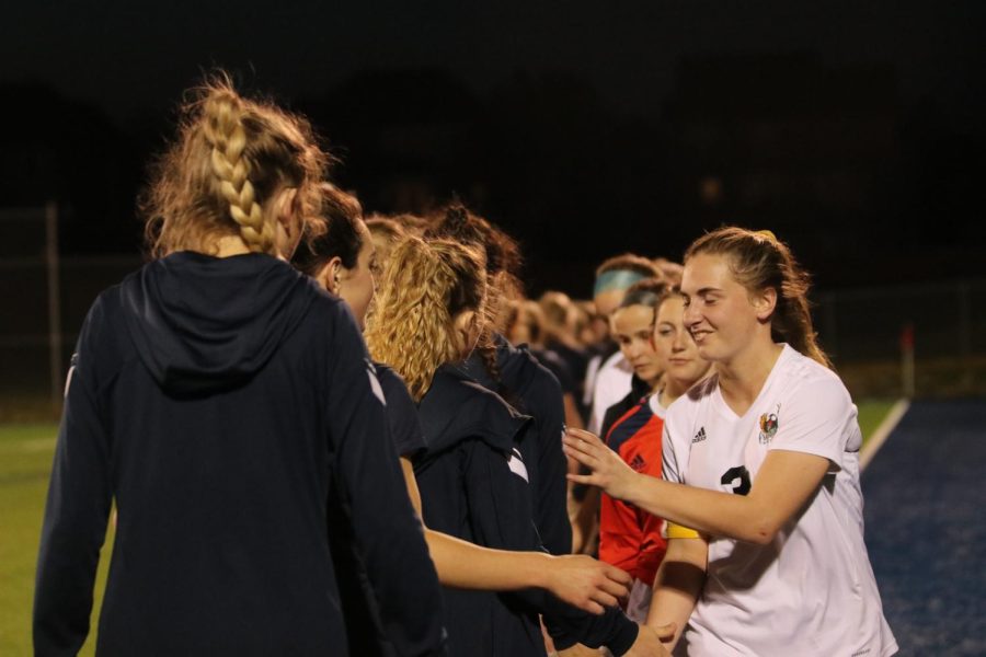 High-fiving the opponent team, the Mill Valley Varsity girls team congratulating them for their win