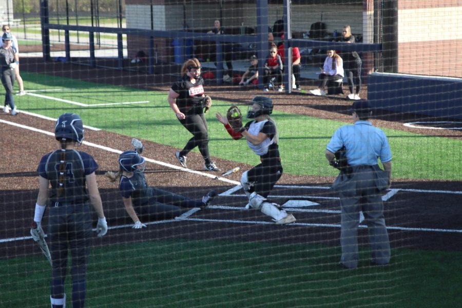 Sliding into home, junior Haley Bryant scores a run making the score 2-0