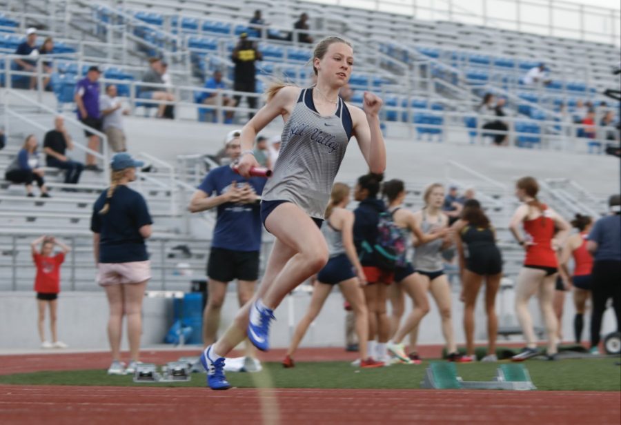 Anchoring for the 4x400 meter relay, freshman Josie Benson rounds the track with the baton in her hand. Benson, along with seniors Quincy Hubert, Katie Schwartzkopf and freshman Addison Long, helped the relay team get  second place with a time of 4:13.95 seconds, several hundreths of a second behind first place finisher Blue Valley West. 