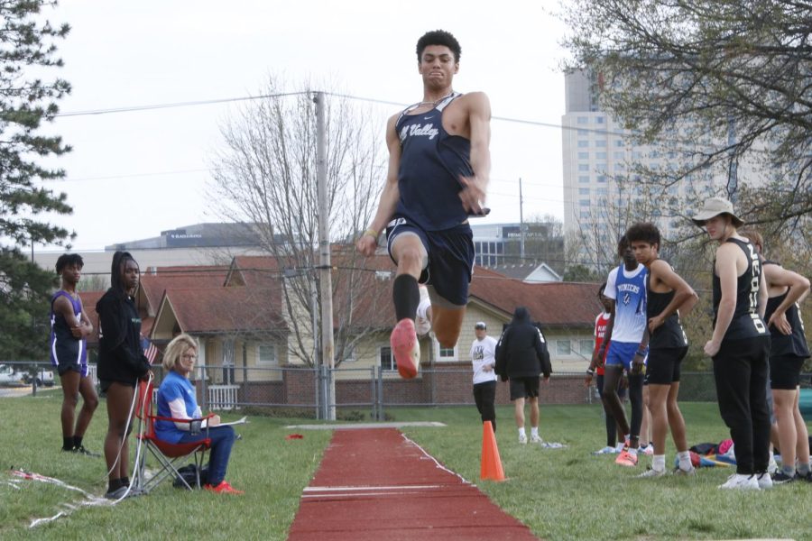 On his final jump, senior Adrian Dimond looks at the sandpit in front of him to see where he will land. Dimond took first place in the triple jump leaping a final distance of 47-6.25 feet, four feet farther than Neosho runner up Isaiah Green Friday, April 22.