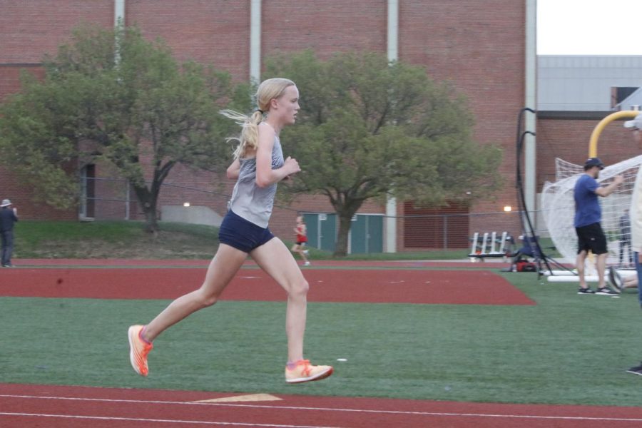 In the lead, freshman Charlotte Caldwell hits the one mile mark during her run in the 3200 meter race. Caldwell finished in first place for the 3200 meter run with a two-mile time of 11:41 seconds, 14 seconds ahead of Blue Valley West runner up Sebastian Poe.