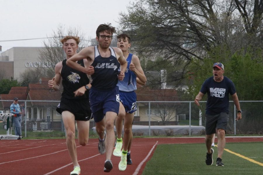 Senior Nic Botkin leads two runners in the 3200 meter run alongside head coach Chris McAfee in the infield who yells words of encouragement. Botkin took third place in the event with a two mile time of 10:10 seconds.